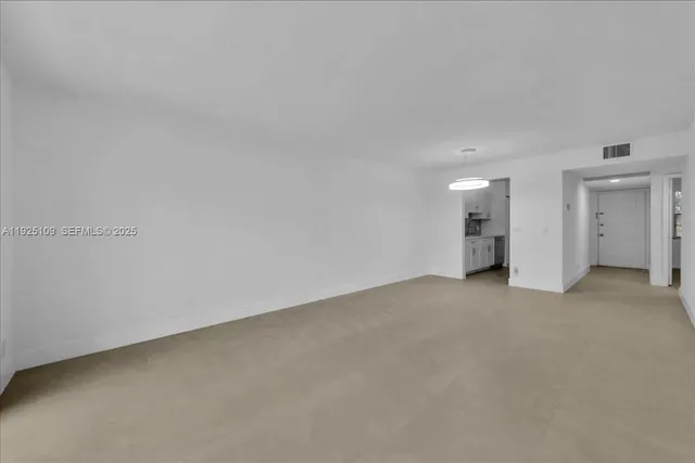 a view of a room with wooden floor and a floor to ceiling window