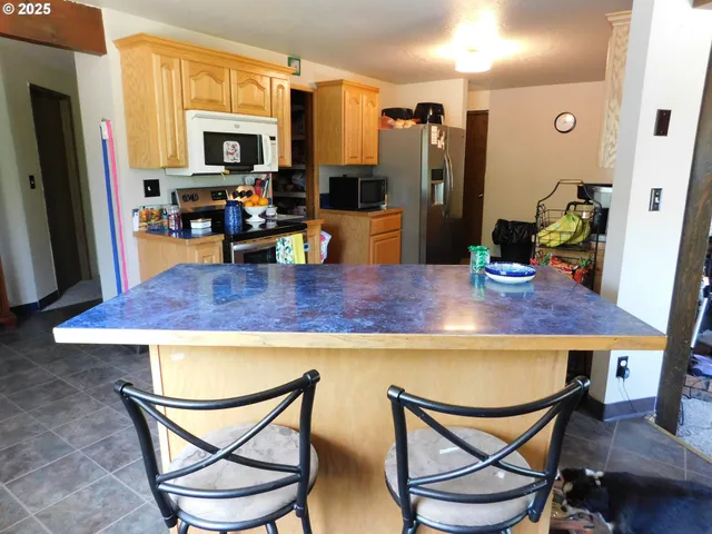 a kitchen view with a dining table and chairs