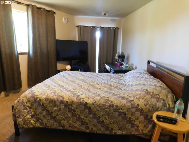 a bedroom with a bed and a flat screen tv