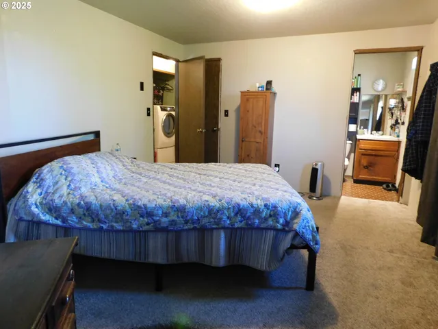 a bedroom with a bed and a chair in it