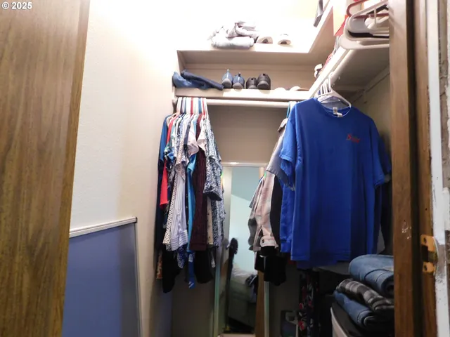 a view of walk in closet with clothes