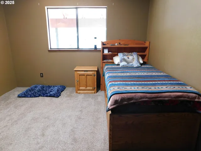 a bed sitting in a bedroom next to a window