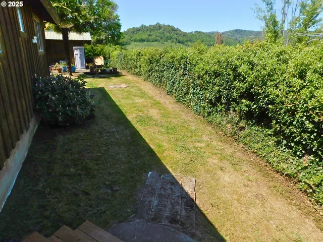 a backyard of a house with barbeque oven table and chairs