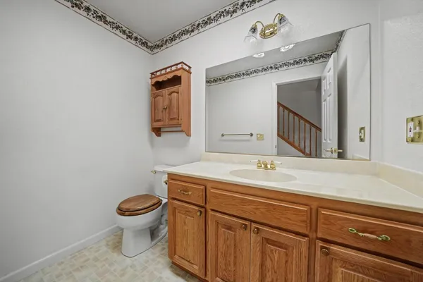 a bathroom with a granite countertop sink a toilet and mirror