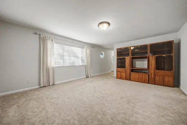 an empty room with window and closet