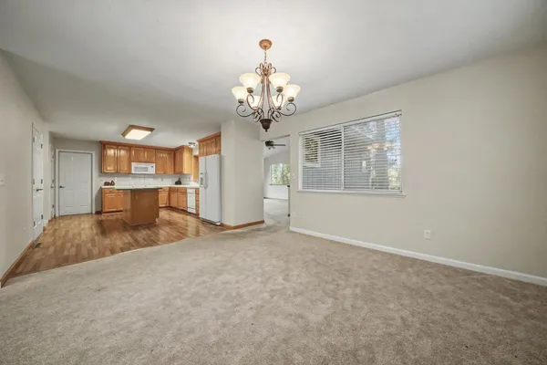 an empty room with chandelier and windows
