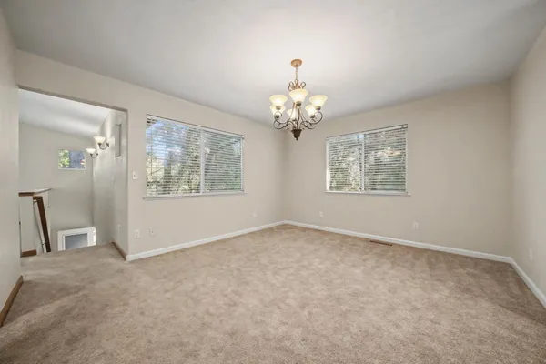 a view of a big room with windows and chandelier fan
