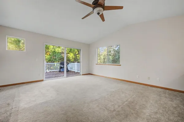 a view of a big room with windows and chandelier fan
