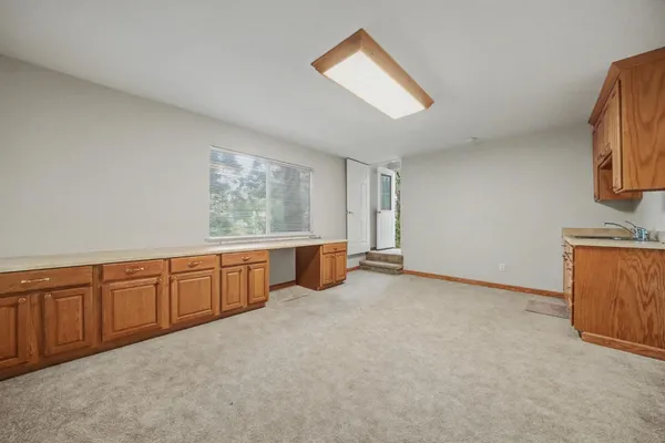 a view of an empty room with closet and a kitchen