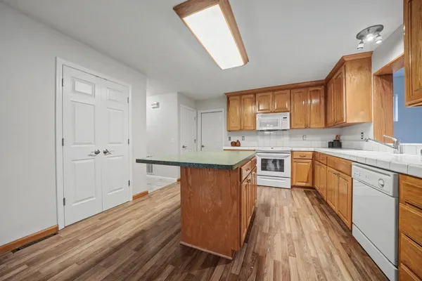 a kitchen with wooden floors and white cabinets