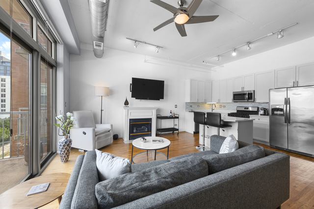 950 West Monroe Street, Unit 616 Chicago, IL 60607 - Photo 5 of 28 a living room with furniture a fireplace and a flat screen tv