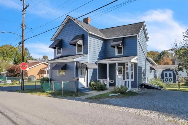 a view of a white house with large windows and a small yard