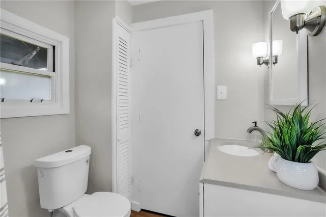 a bathroom with a toilet a sink and a mirror