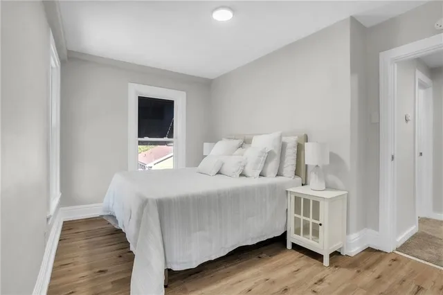 a bedroom with a bed and a flat tv screen on dresser