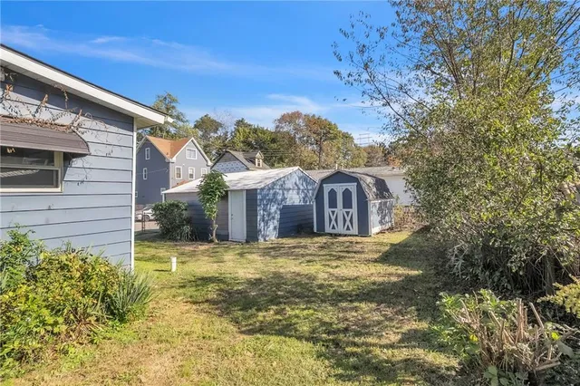 a view of a house with a large tree and a yard