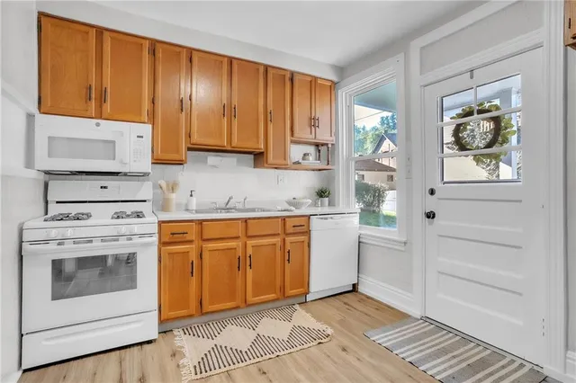 a kitchen with white cabinets and white appliances