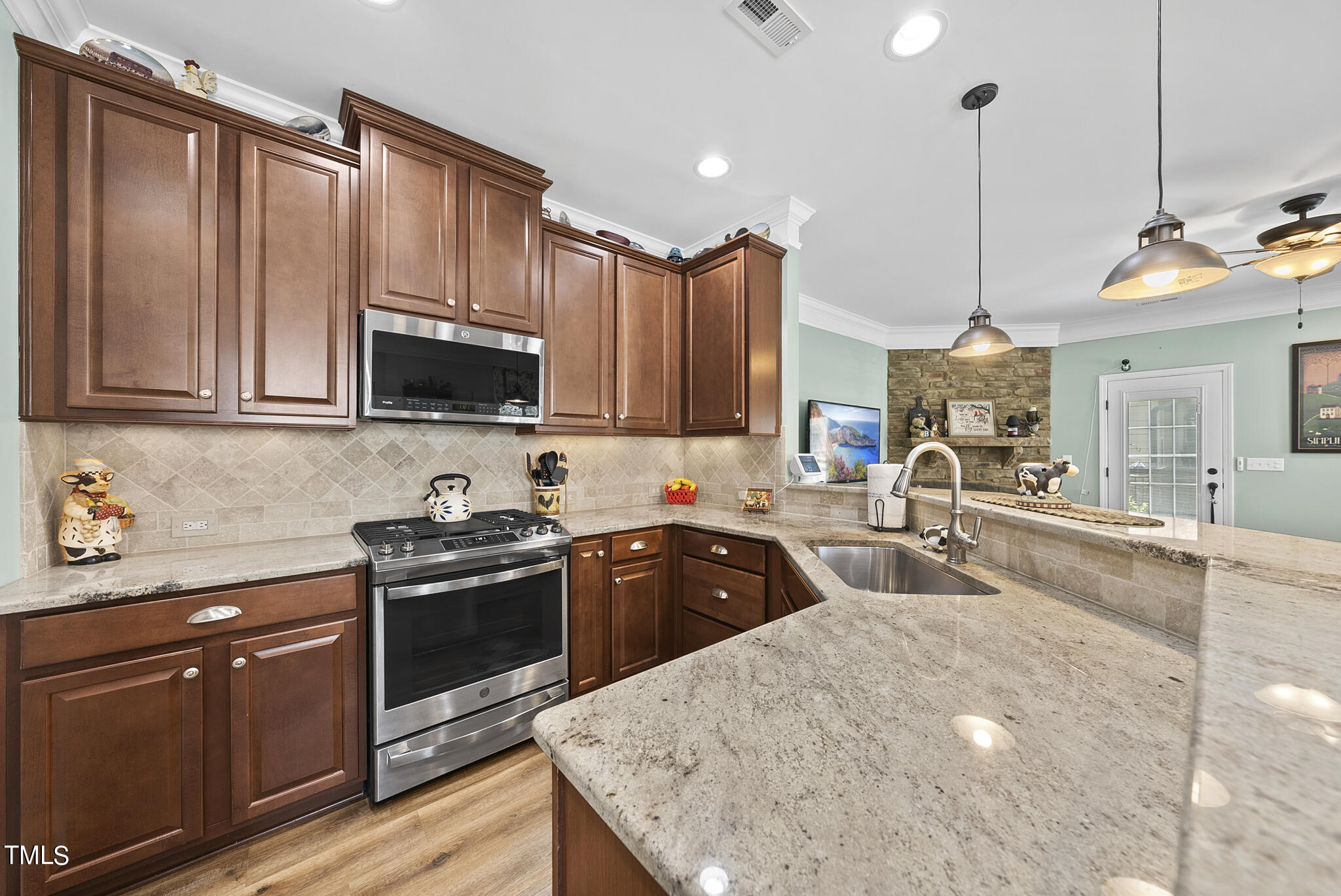 699 Wickham Ridge Road Apex, NC 27539 - Photo 12 of 36 a kitchen with stainless steel appliances granite countertop a sink a stove and a wooden cabinets