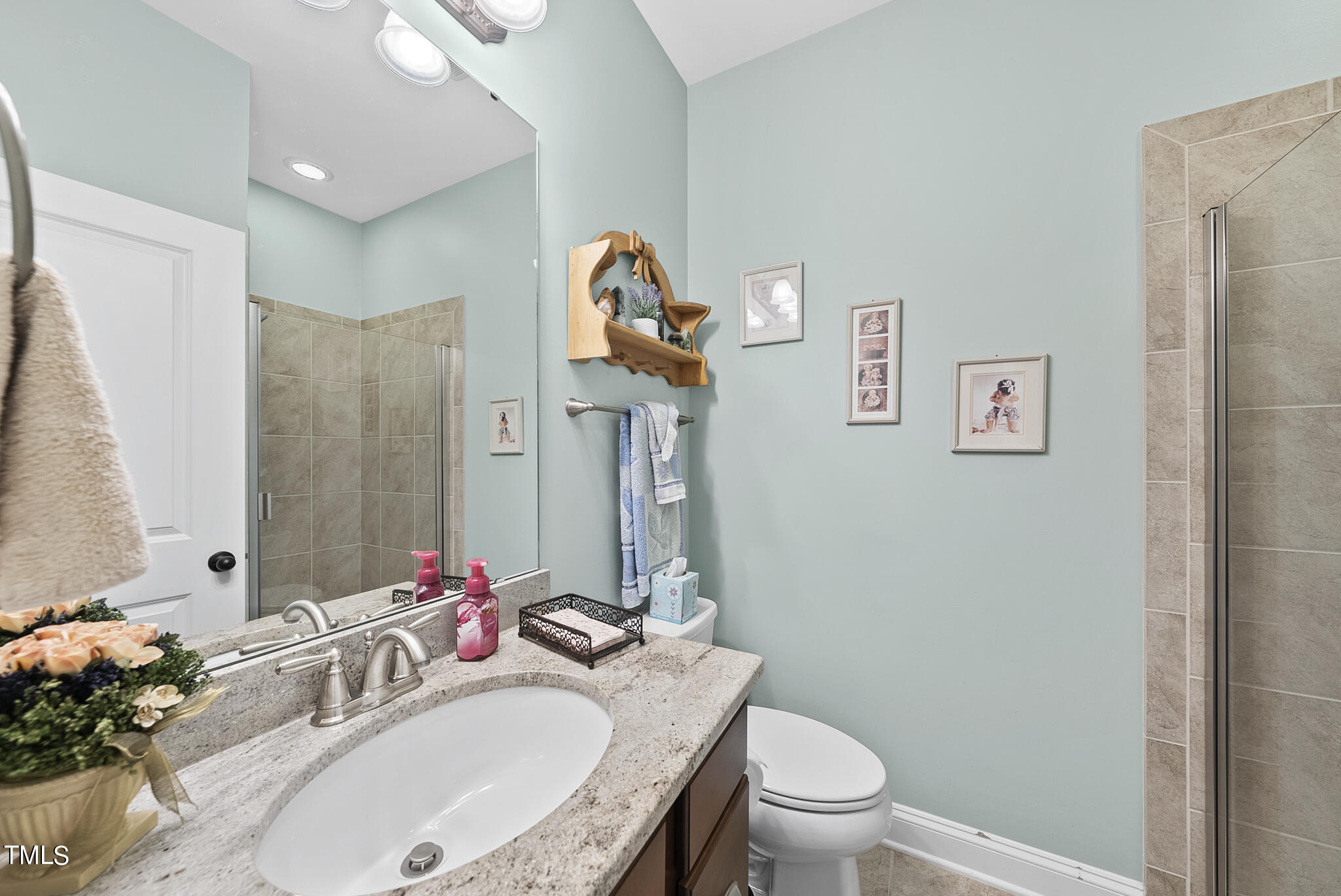 699 Wickham Ridge Road Apex, NC 27539 - Photo 18 of 36 a bathroom with a granite countertop sink mirror vanity and toilet