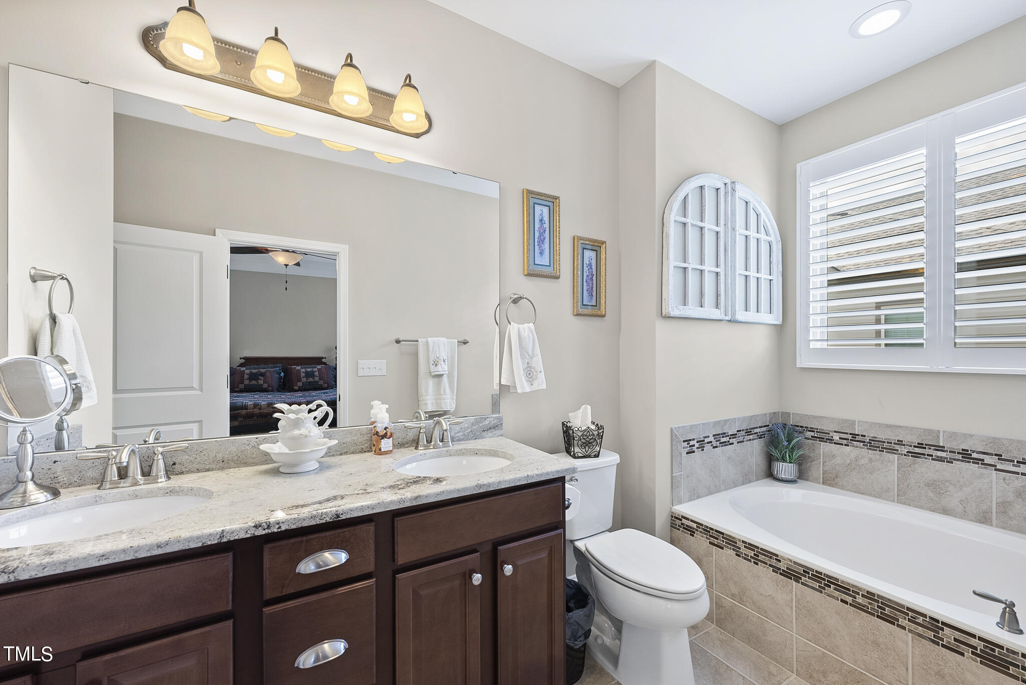 699 Wickham Ridge Road Apex, NC 27539 - Photo 23 of 36 a bathroom with a granite countertop toilet a sink and a bathtub