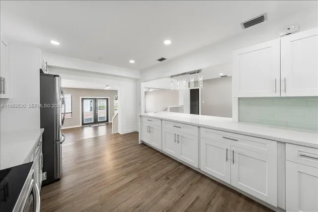 a view of a hallway with wooden floor and entryway