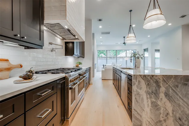 a kitchen with stainless steel appliances granite countertop a refrigerator and a stove