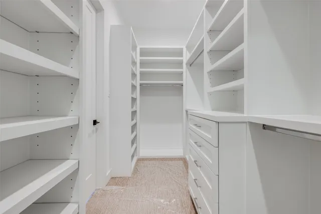 a view of walk in closet with empty racks