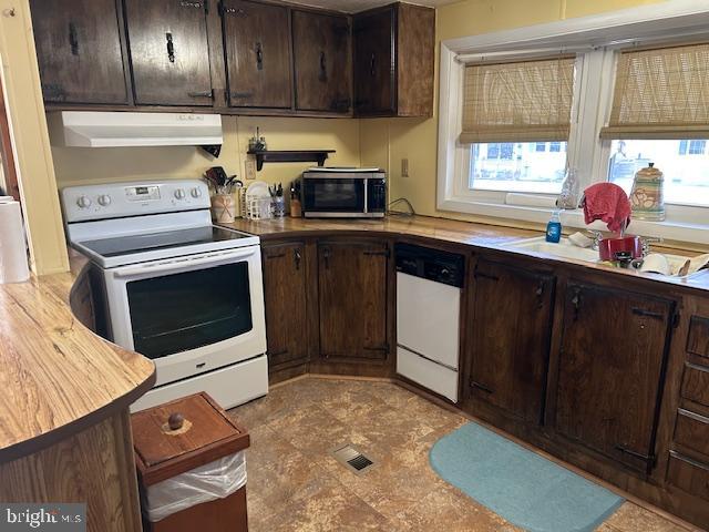 9916 Golf Course Road, Unit 61 Ocean City, MD 21842 - Photo 13 of 18 a kitchen with stainless steel appliances a stove a sink and a microwave