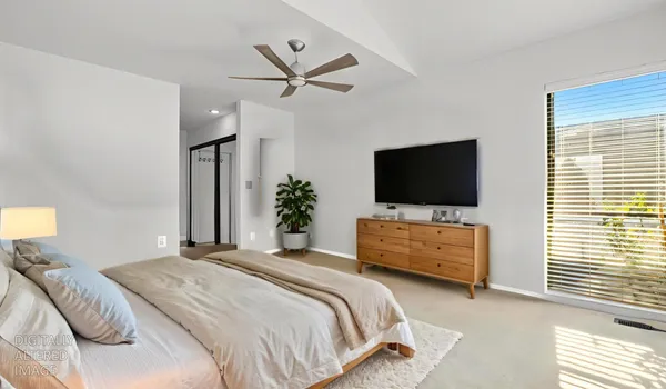 a bedroom with a bed tv and a window