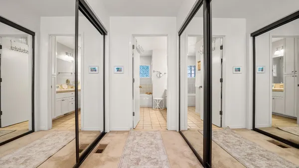 a view of a hallway with a livingroom and a bathroom