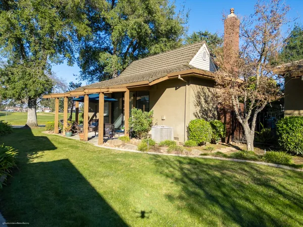 a view of a house with backyard and sitting area