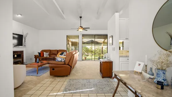 a living room with furniture a fireplace and a floor to ceiling window