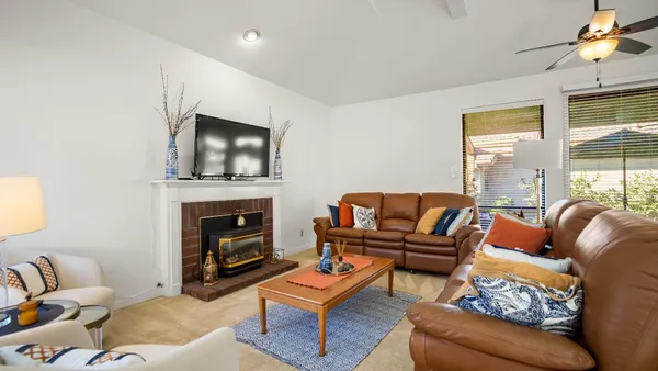 a living room with furniture a flat screen tv and a fireplace