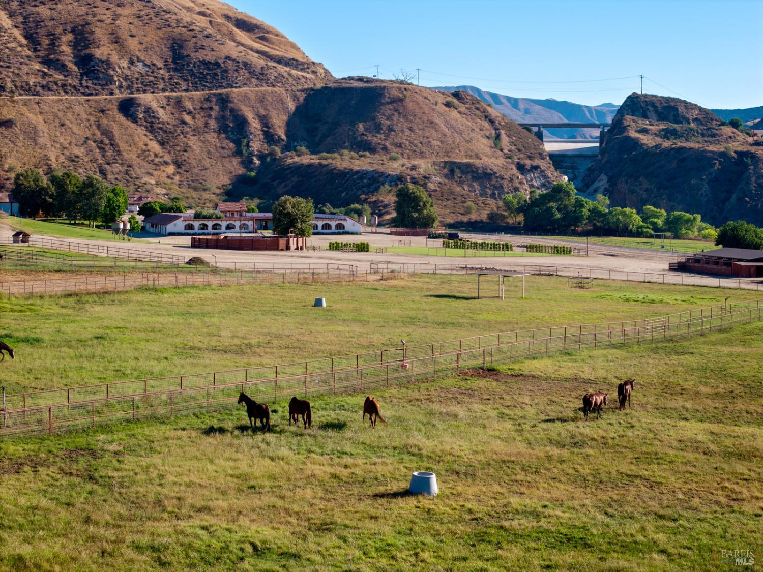 3800-3820 Piru Canyon Road Piru, CA 93040 - Photo 13 of 30 a view of an swimming pool with a lawn chairs under an umbrella