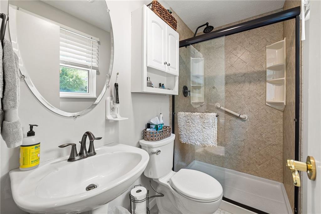 75 Fawnvue Drive McKees Rocks, PA 15136 - Photo 25 of 46 a bathroom with a sink a mirror a toilet and a window