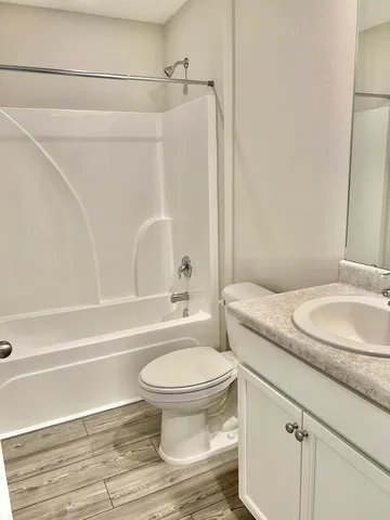 a bathroom with a granite countertop toilet sink and shower
