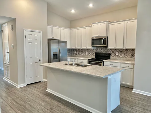a kitchen with stainless steel appliances granite countertop a refrigerator stove microwave and sink