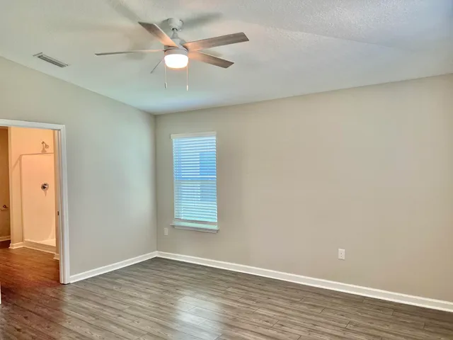 wooden floor in an empty room with a window