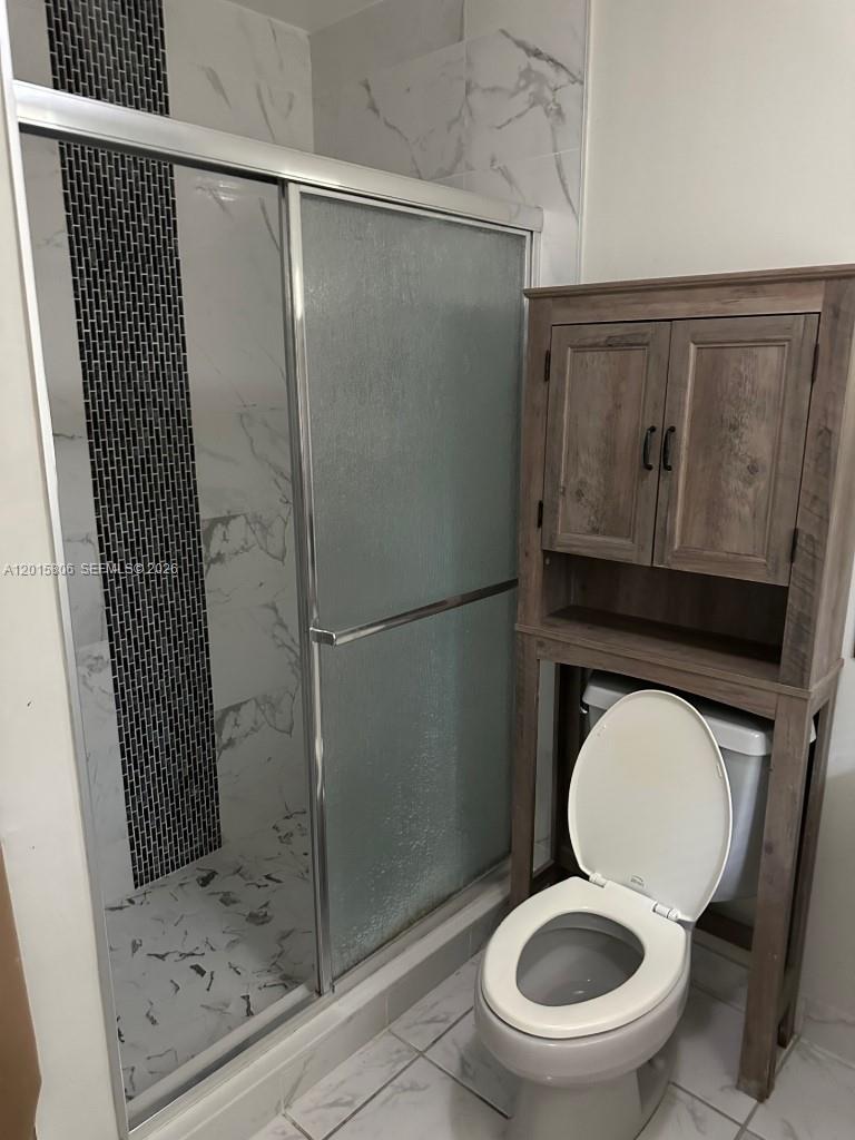 19191 Southwest 232nd Street Miami, FL 33170 - Photo 10 of 10 a bathroom with a granite countertop toilet and a shower
