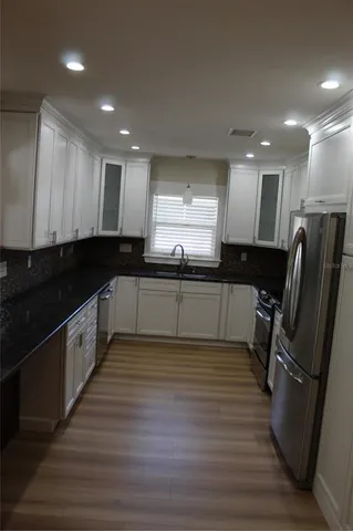 a large kitchen with stainless steel appliances granite countertop a stove and a sink
