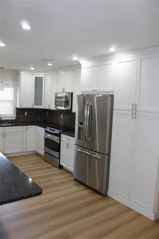a kitchen with granite countertop a refrigerator and a sink