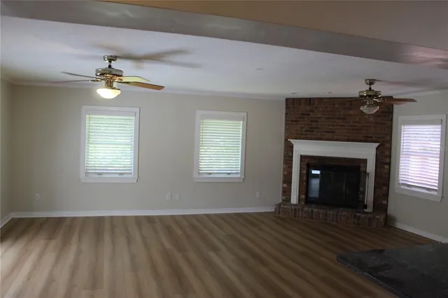 wooden floor fireplace and windows in an empty room