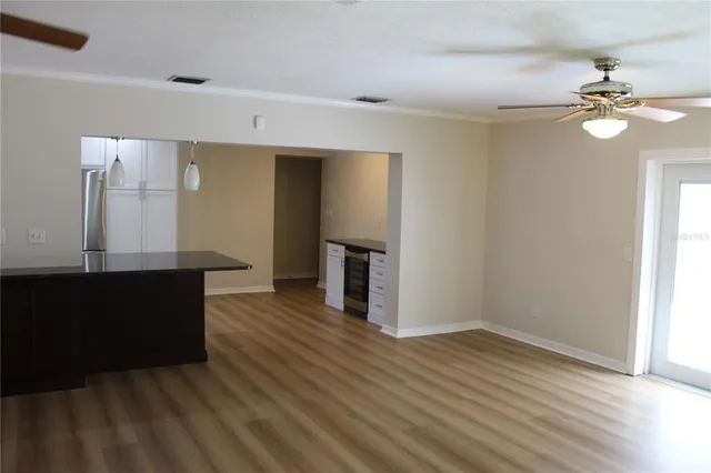 a view of a kitchen with wooden floor and a ceiling fan