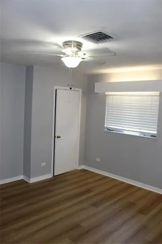 a view of a room with wooden floor and chandelier fan