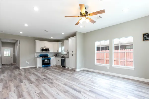 a kitchen with stainless steel appliances granite countertop a refrigerator sink and white cabinets