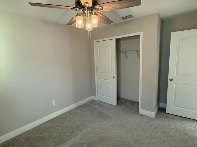 an empty room with a fan and a fan