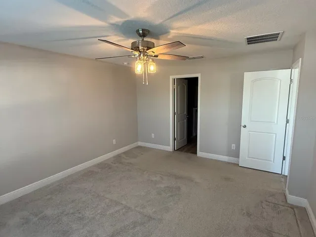 an empty room with a fan and a fan