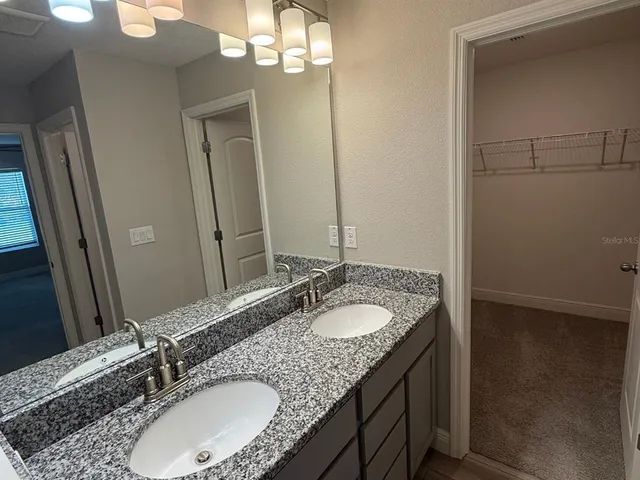 a bathroom with a granite countertop sink and a mirror