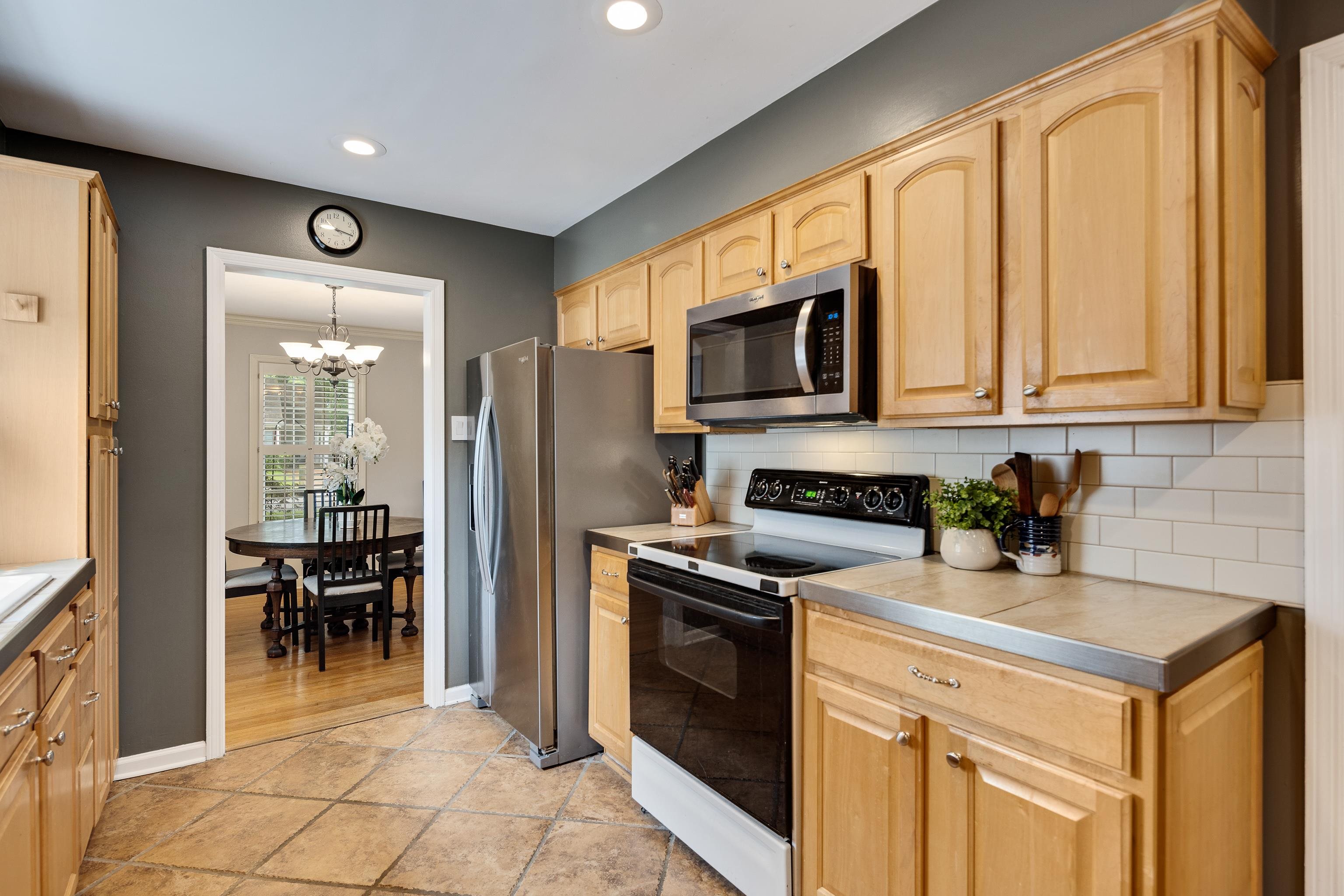 4474 Cherrydale Road Memphis, TN 38117 - Photo 11 of 35 a kitchen with stainless steel appliances granite countertop a stove a sink and a microwave
