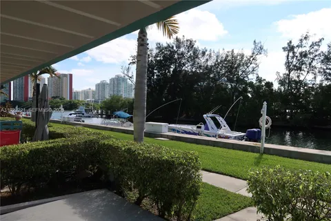 a view of swimming pool with outdoor seating and trees in the background