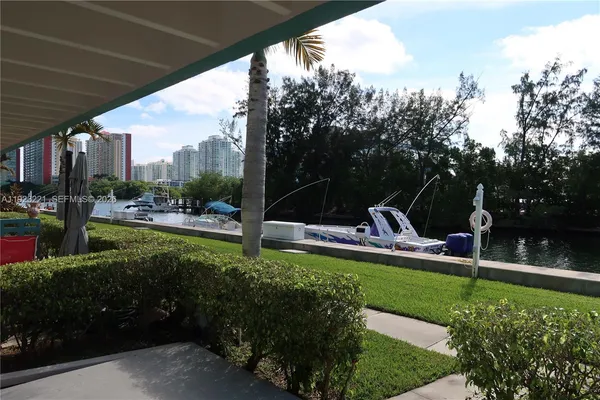 a view of swimming pool with outdoor seating and trees in the background